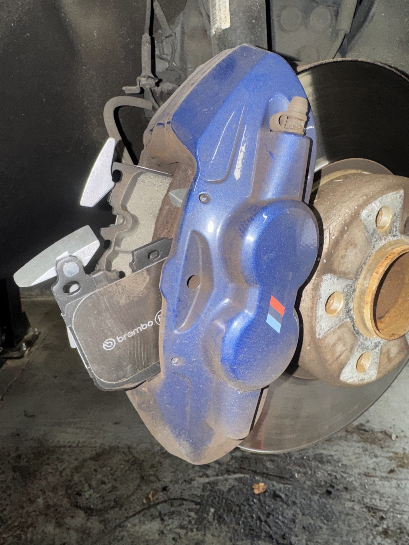 A blue Brembo brake caliper with new pads fitted to a hub